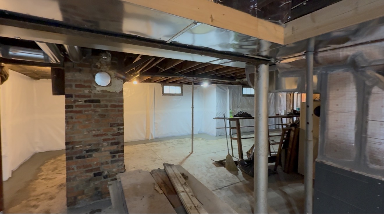Completed basement waterproofing system with vapor barrier and structural supports — Overland Park, KS
