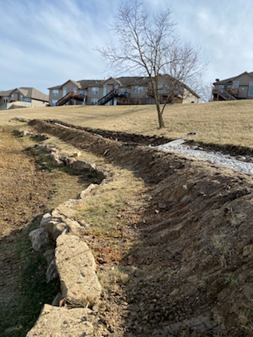 Drainage swale trench in progress on subdivision hillside — Lee's Summit, MO