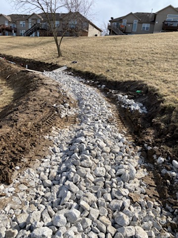 Completed rock drainage swale with catch basin — Lee's Summit, MO