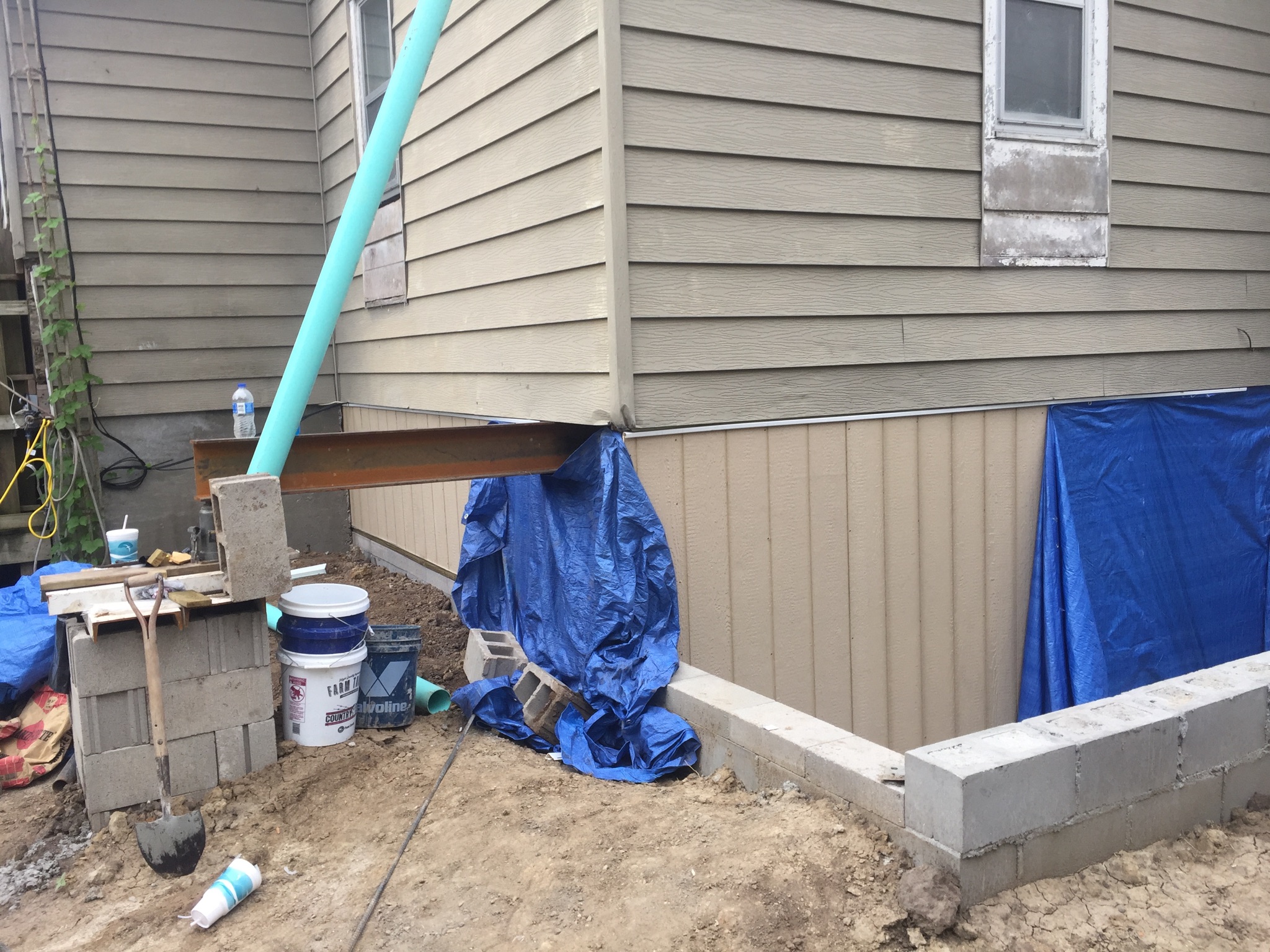 Exterior foundation support beam during pier installation — Lenexa, KS