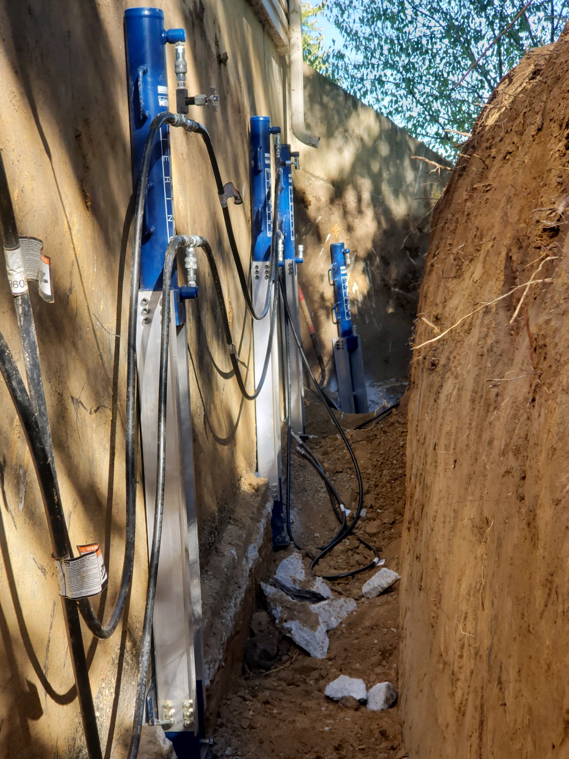 Exterior push piers installed along foundation wall — West Des Moines, IA