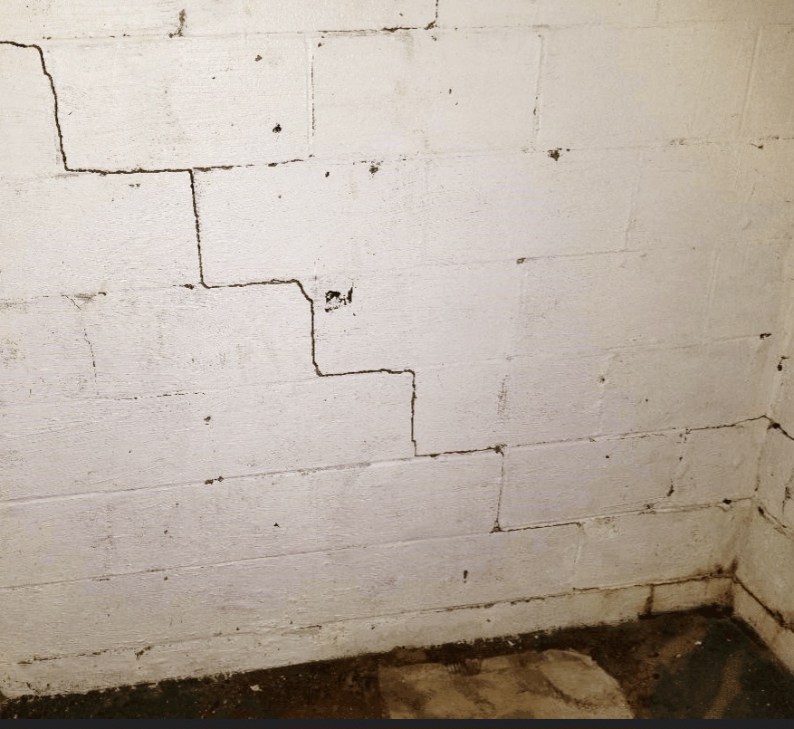 Classic stair-step cracking in painted block basement wall — Independence, MO