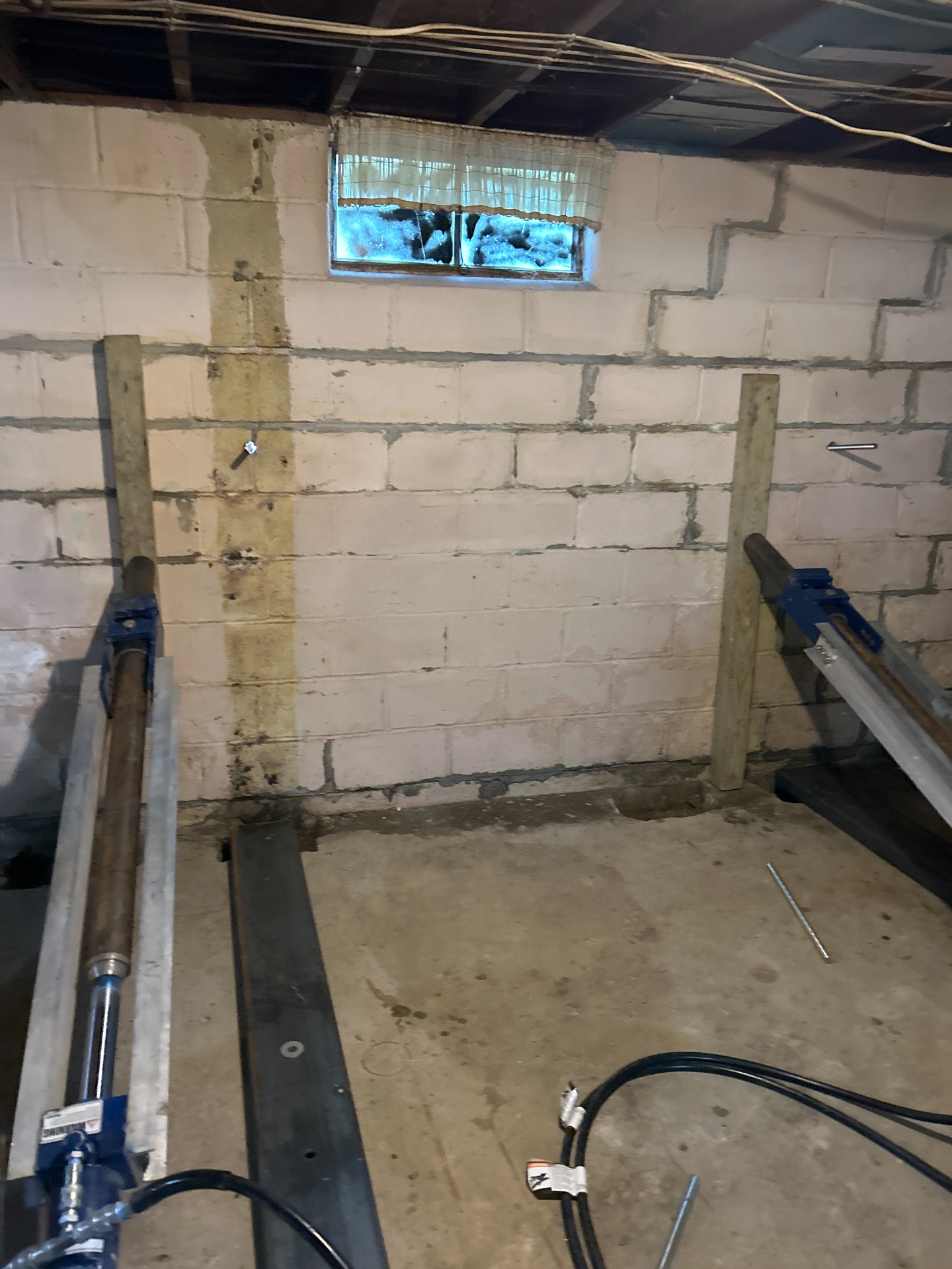 Hydraulic press pushing steel brace against bowing wall — Independence, MO