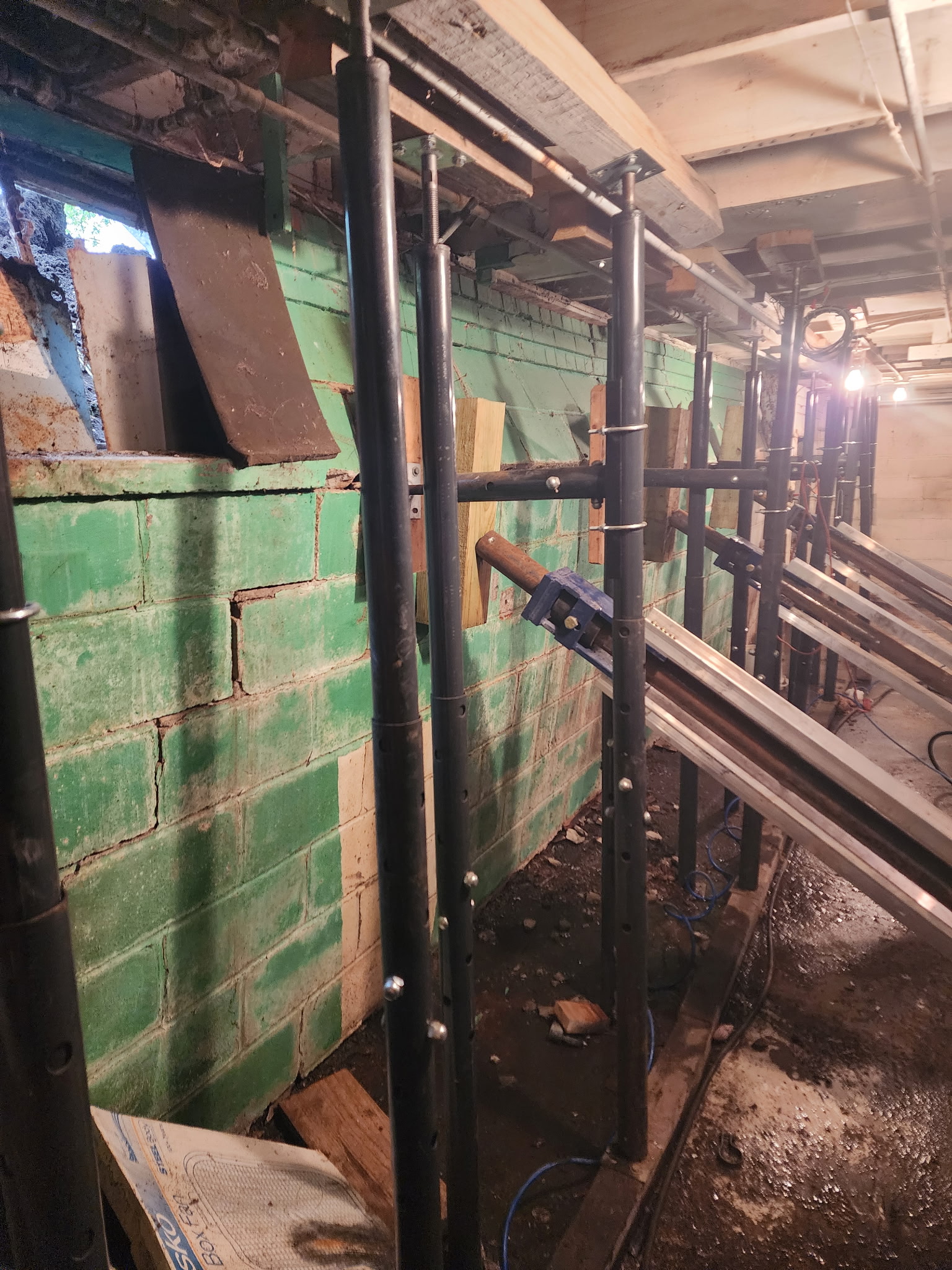 Steel I-beam wall braces installed against bowing basement wall — Westport, Kansas City, MO