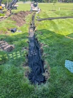 Excavator and fabric-lined drainage trench — Urbandale, IA
