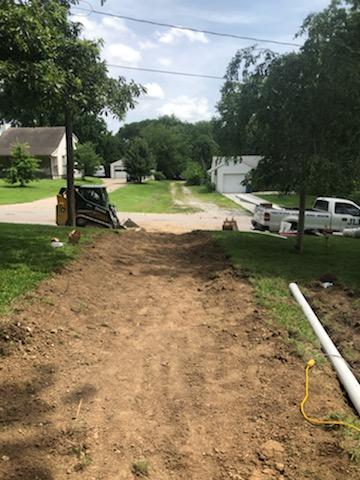 Skid steer trenching through yard for drainage pipe — Urbandale, IA