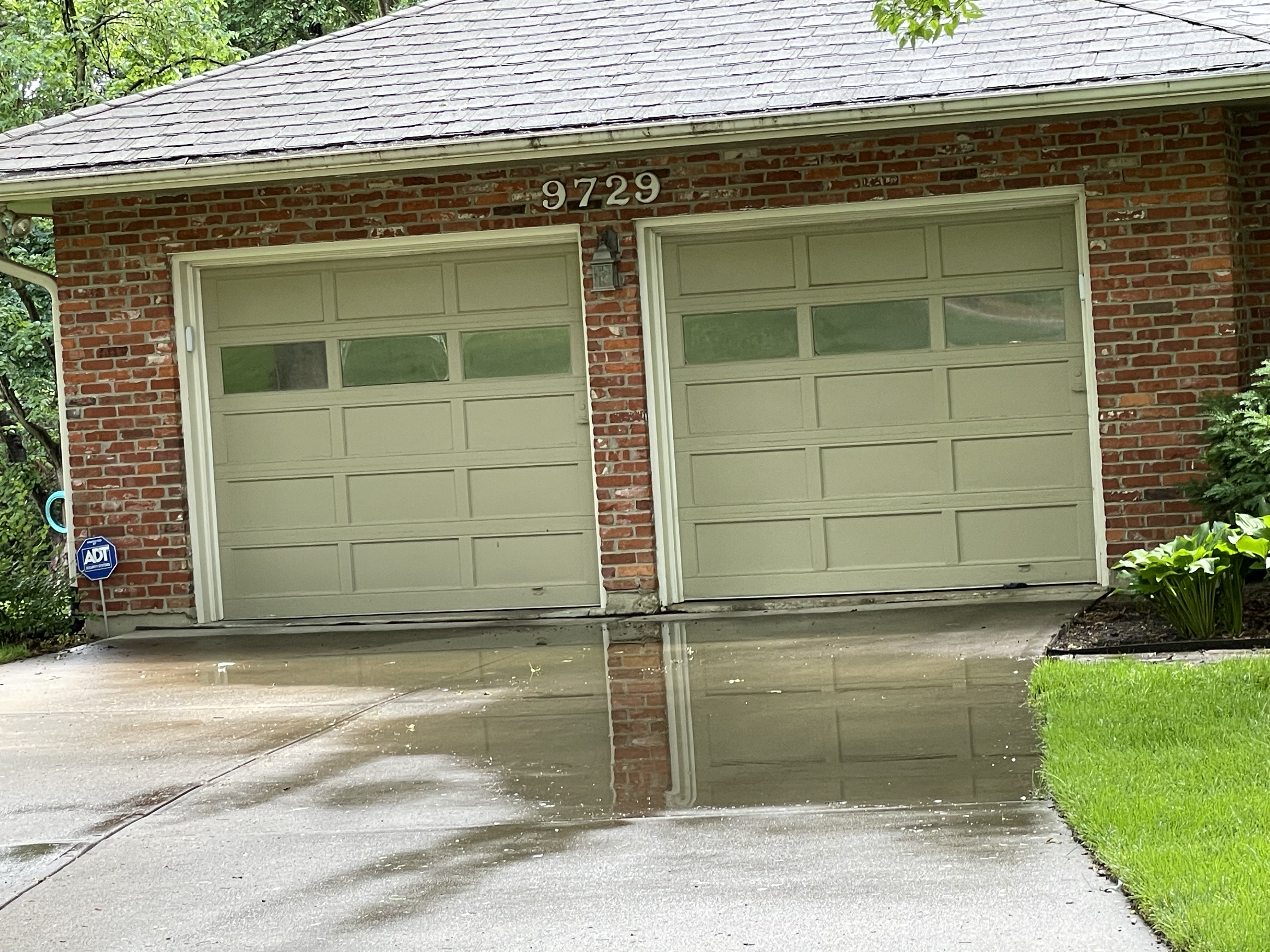 Water pooling against garage doors on sunken driveway — Leawood, KS
