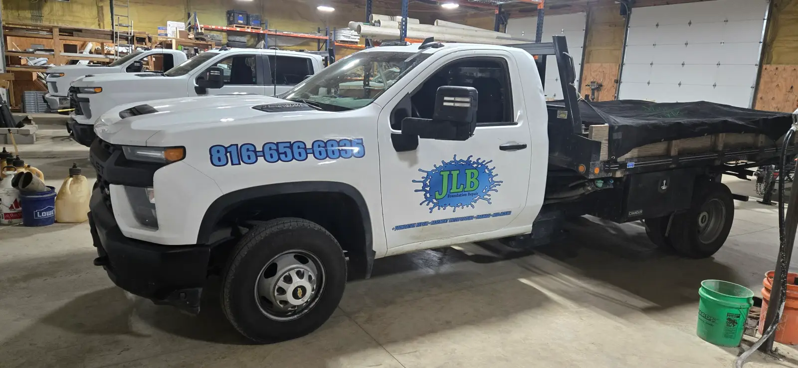 Warehouse interior showing JLB branded service truck fleet