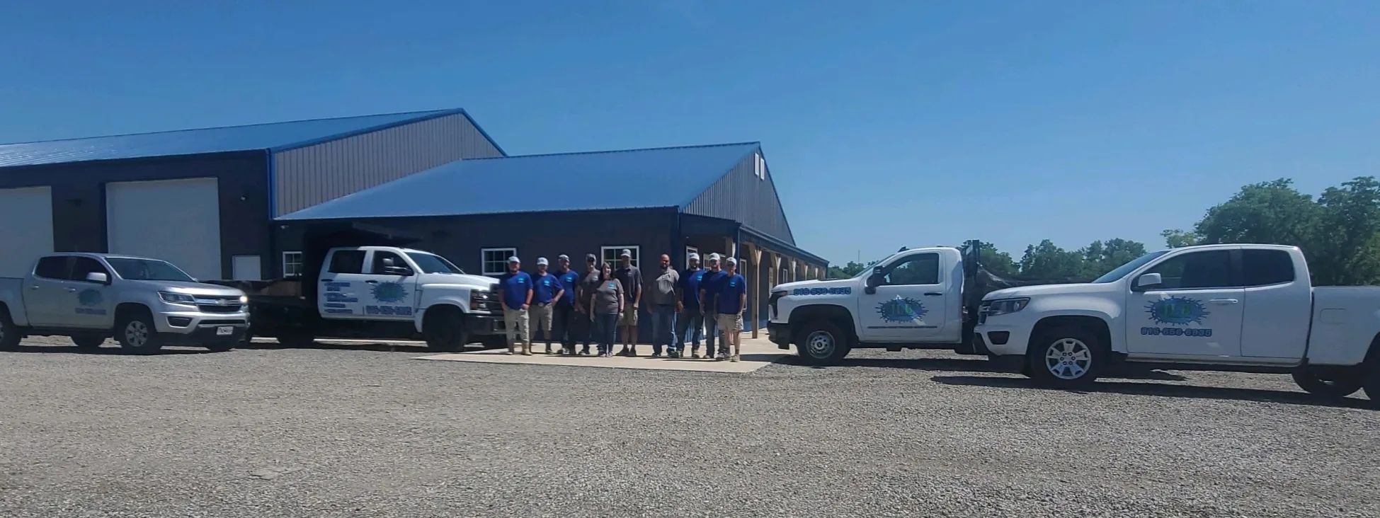 JLB company warehouse building exterior with branded truck fleet outside