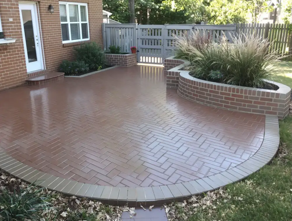 Brick-pattern wraparound concrete patio — patios by JLB in Ames, Iowa