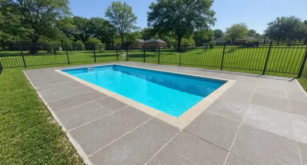 Broom-finished concrete pool deck around a fiberglass pool — pool decks by JLB in Ames, Iowa