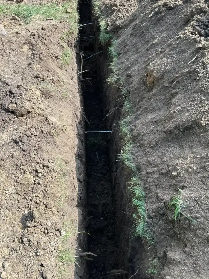 Narrow trench excavated through soil