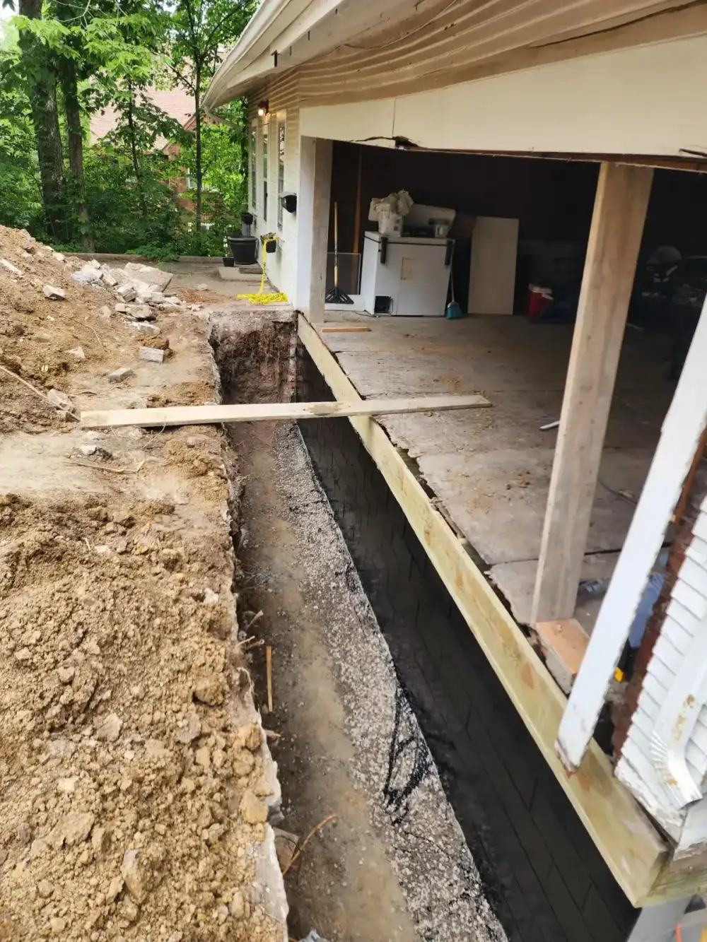 Fresh concrete fills a new foundation footing during excavation work in Merriam
