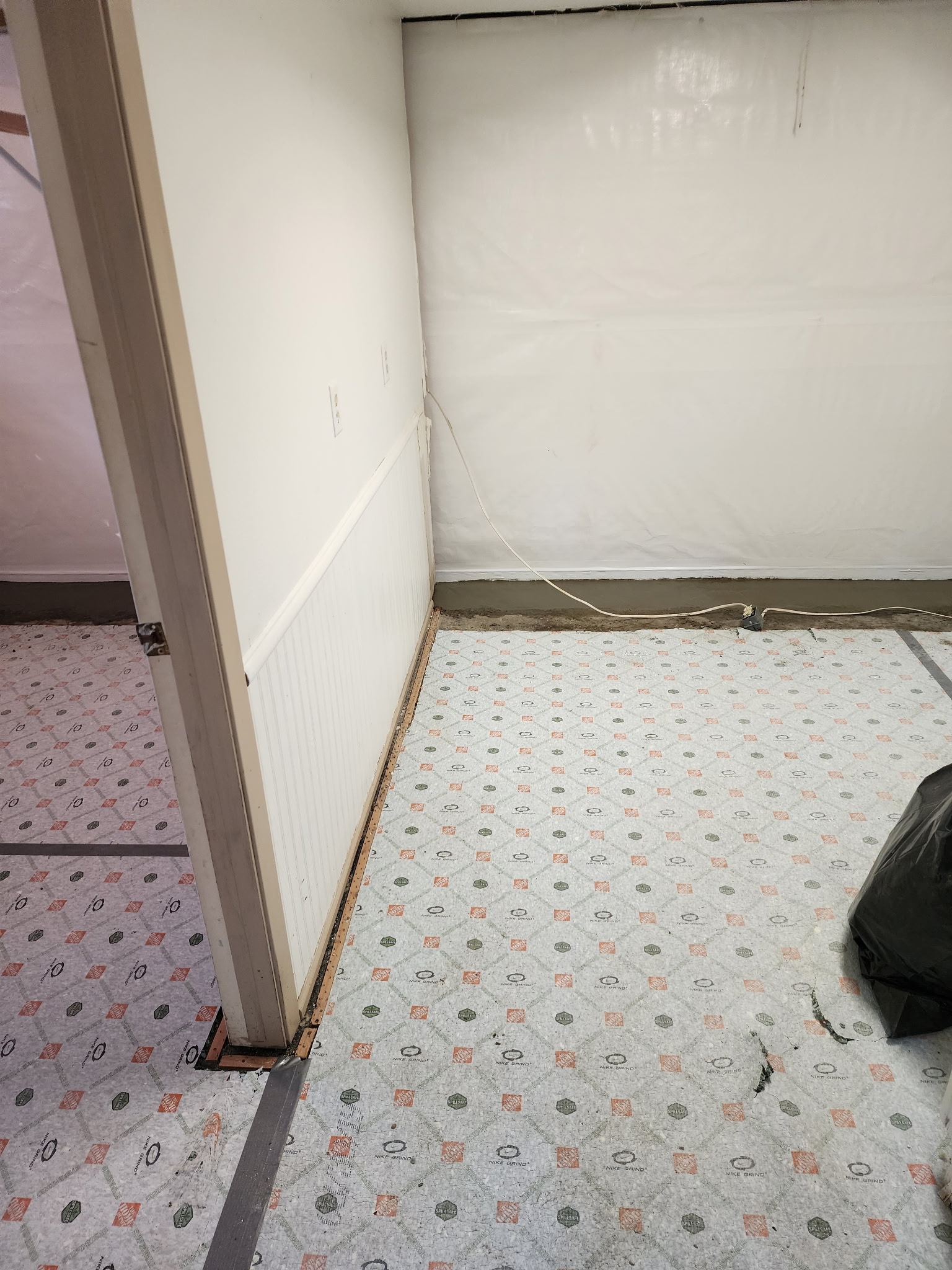 Vapor barrier sealed to wall in finished basement