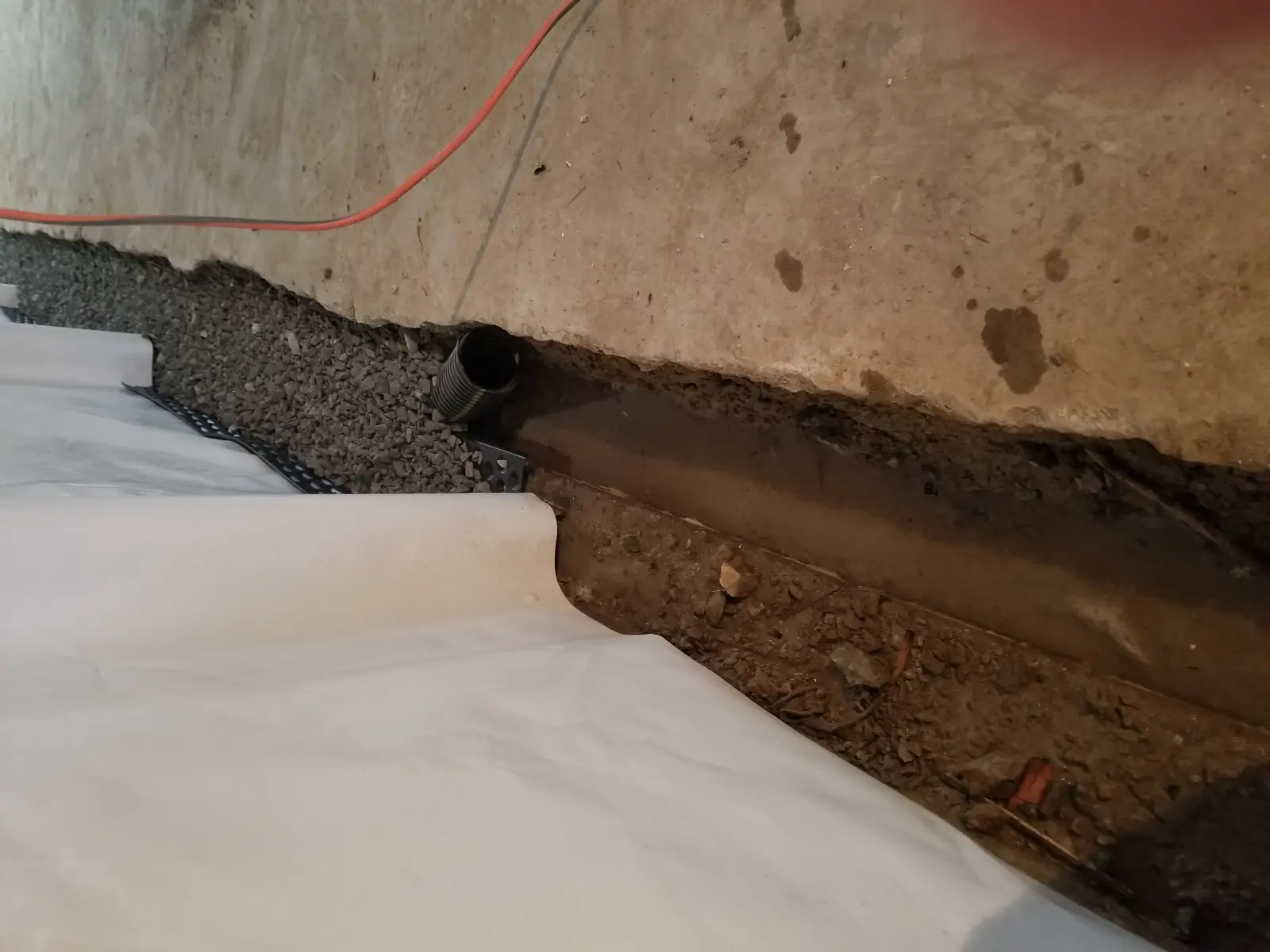 Drain tile pipe with gravel in basement trench
